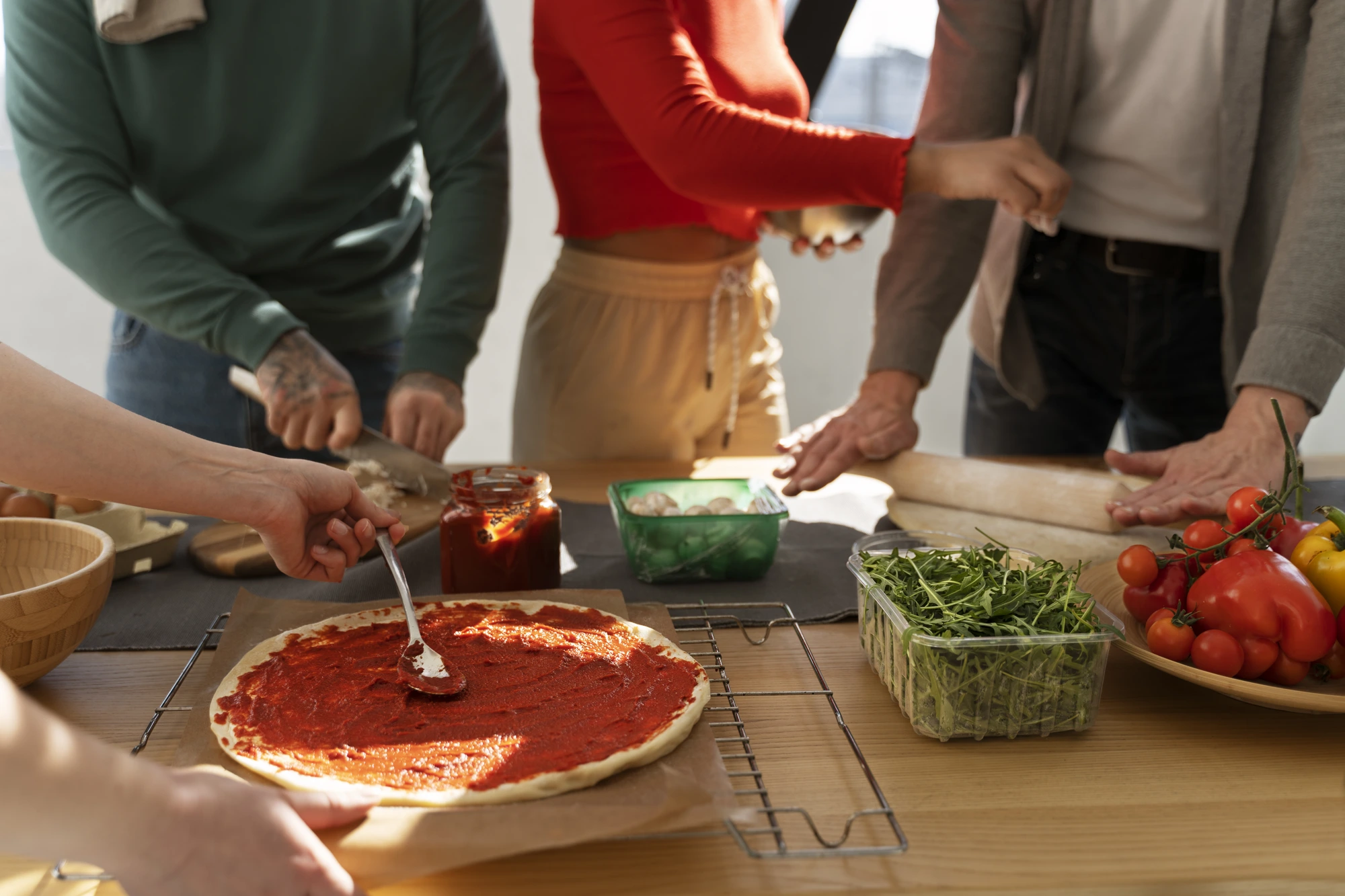 Familia cocinando una pizza juntos en un taller de cocina